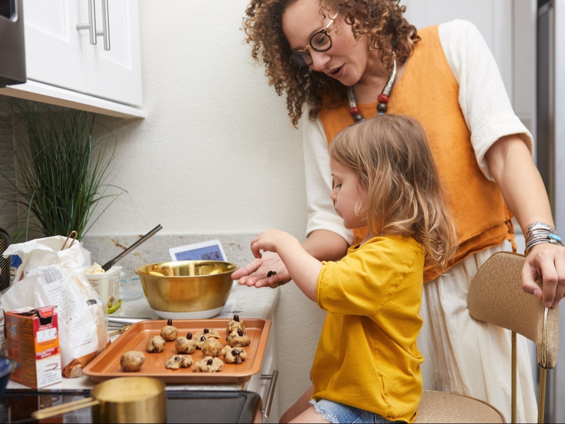 Una madre en la cocina haciendo galletas con una niña