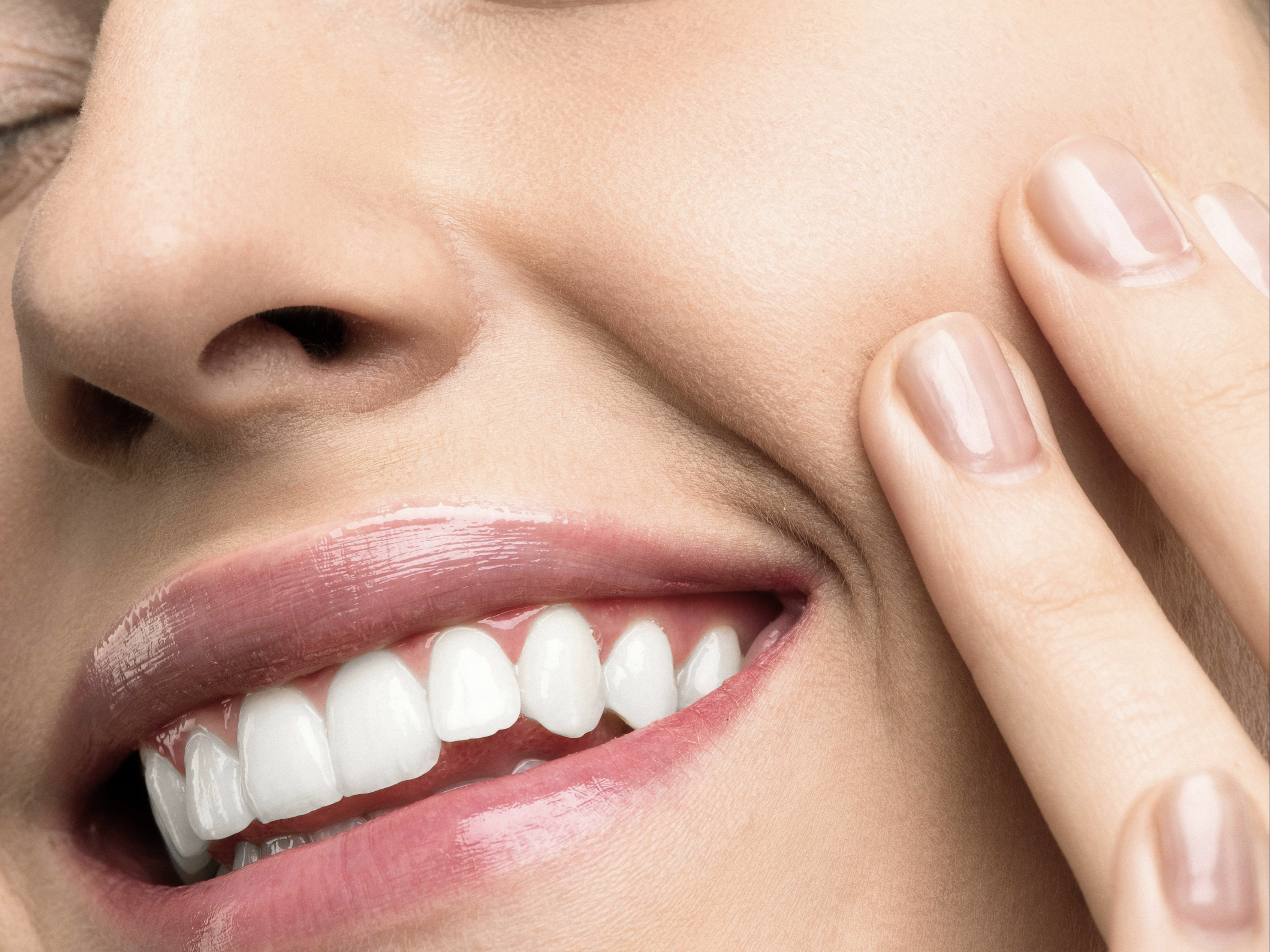 Chica con los ojos cerrados sonriendo enseñando sus dientes 